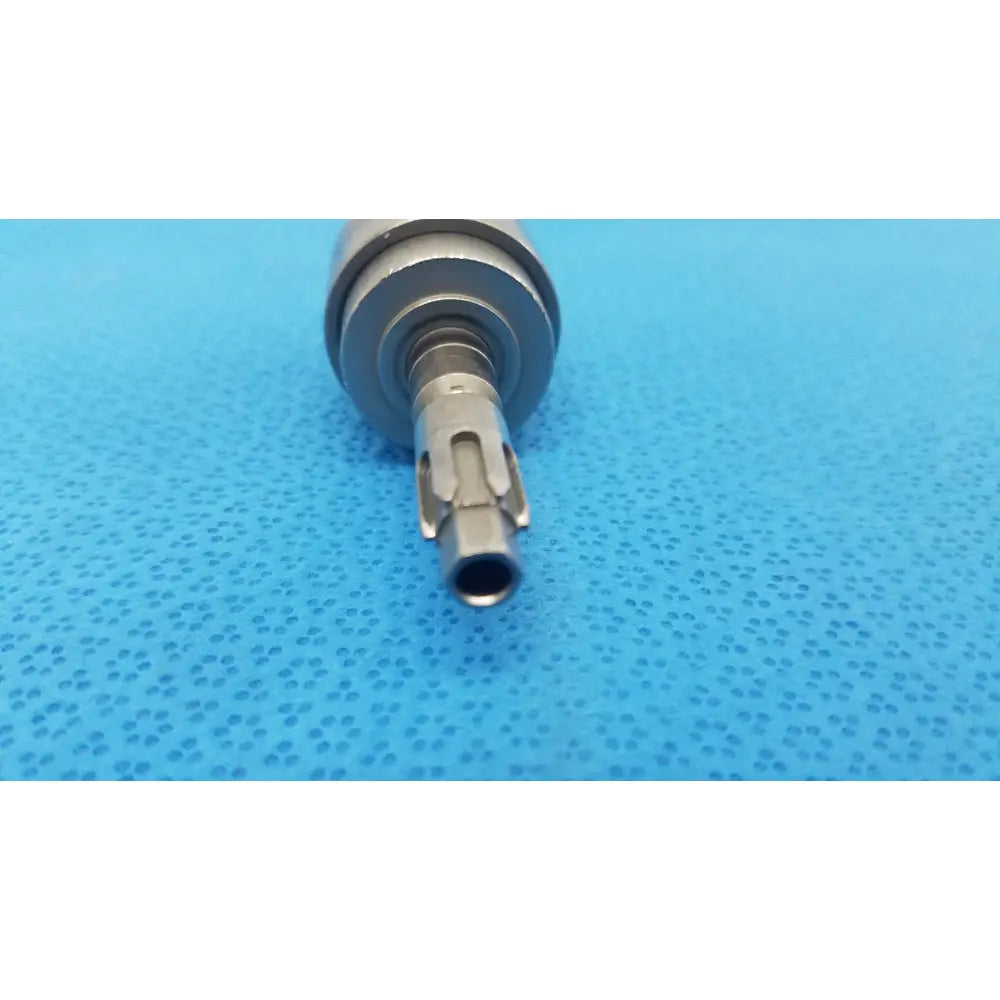 Silver-colored metal dental handpiece with textured cylindrical body and precision-engineered tip for hudson modified trinkle use