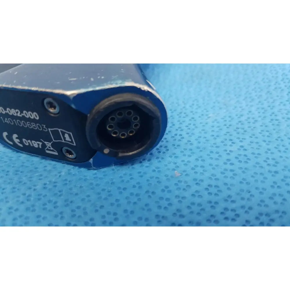 Blue industrial connector with circular multi-pin port and serial numbers on the back of stryker remb wiredriver handpiece