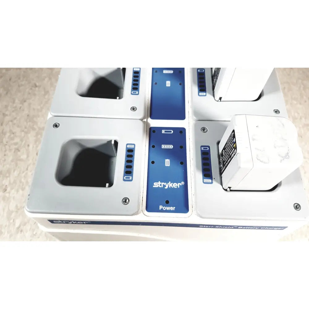 White stryker 8-slot steri-shield flyte battery charging station with blue control panels and labeled battery slots