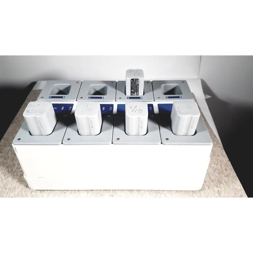 Stryker white rectangular flyte battery charging station with four slots holding white cylindrical flyte batteries