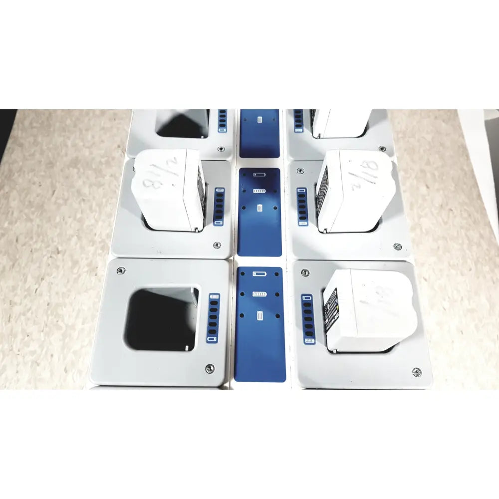 White rectangular battery packs with blue circuit boards and silver screws in stryker 8-slot steri-shield flyte battery charging station