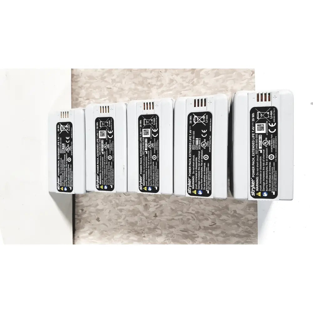 White rectangular styker power pack extended flyte batteries with black labels in stryker 8-slot steri-shield flyte battery charging station