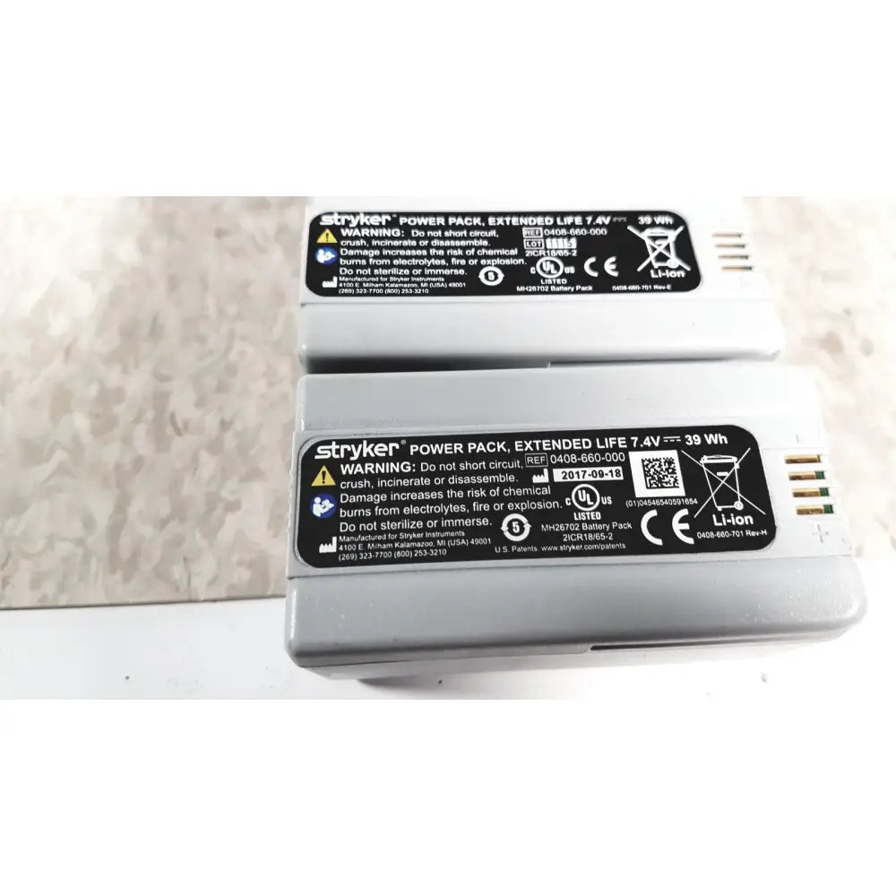 Gray rectangular stryker flyte battery with black label and gold contacts for flyte battery charging station use