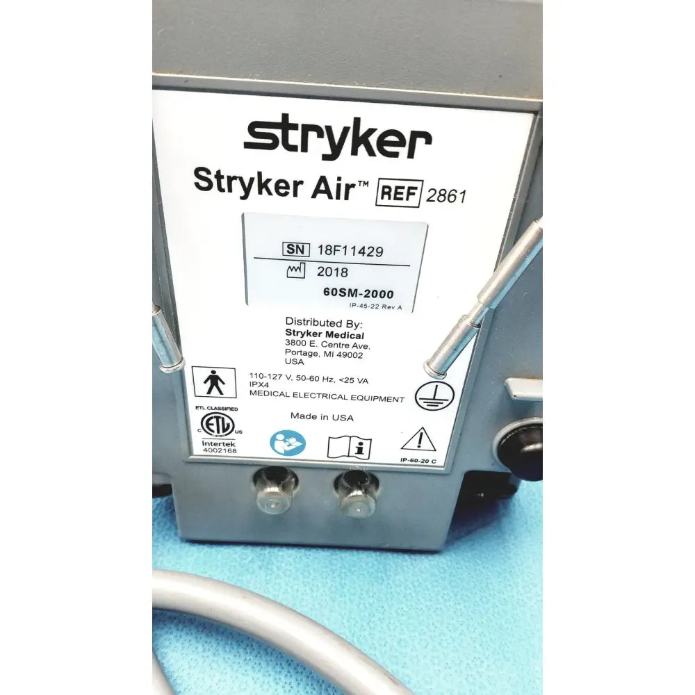Gray metal stryker air loss pump 2861 with white label showing model and serial number details on the back side