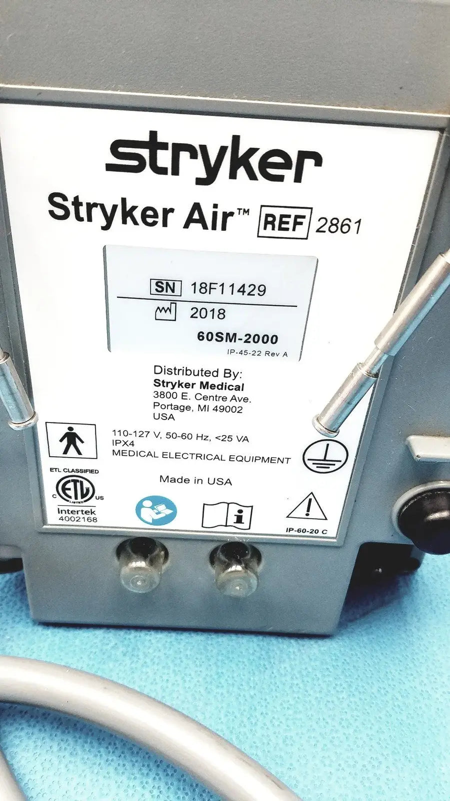 Gray metal stryker air loss pump 2861 with white label showing model and serial number details on the back side