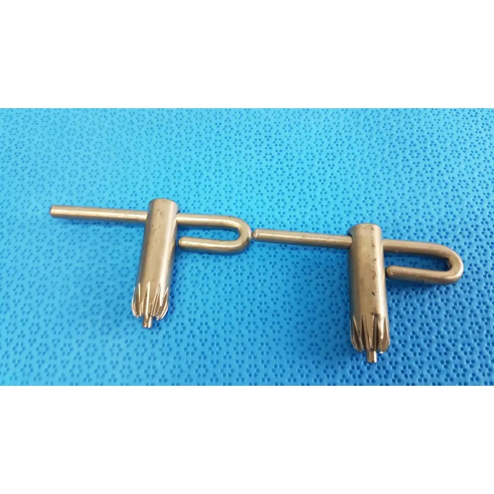 Gold-colored metal stryker chuck key with t-shaped handle and two adjustable jaws for surgical drill systems lot of 2