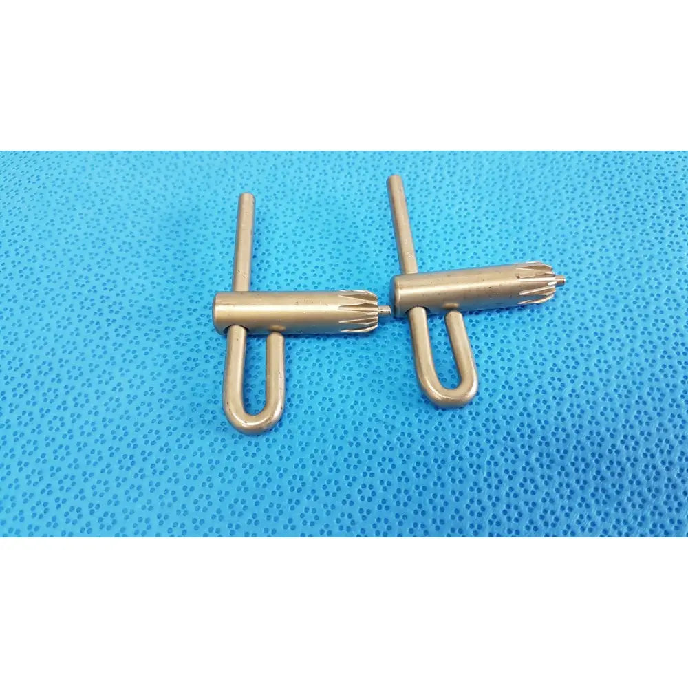 Two brass-colored metal stryker chuck keys with u-shaped bases and threaded ends for surgical drill systems lot of 2