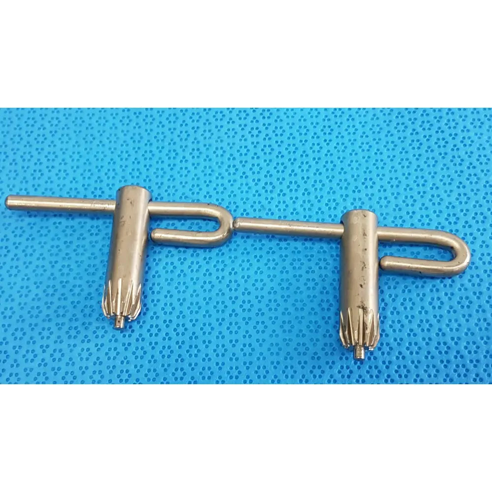 Metallic stryker chuck key with two cylindrical gear-like ends and central connecting bar for surgical drill systems lot of 2