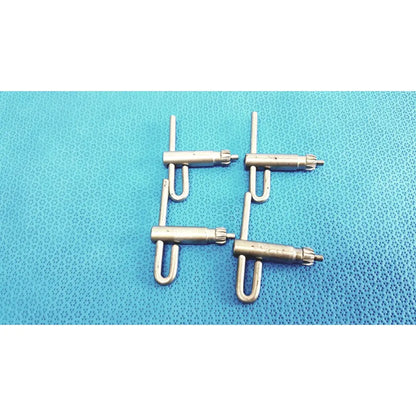 Four metallic u-shaped stryker chuck keys with threaded ends arranged on textured blue surface for surgical drills