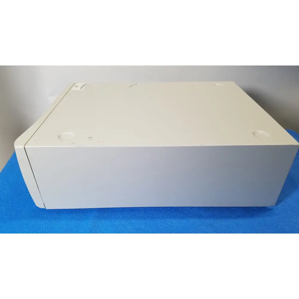 Off-white rectangular stryker core powered instrument driver with rounded edges and four circular indentations on top surface