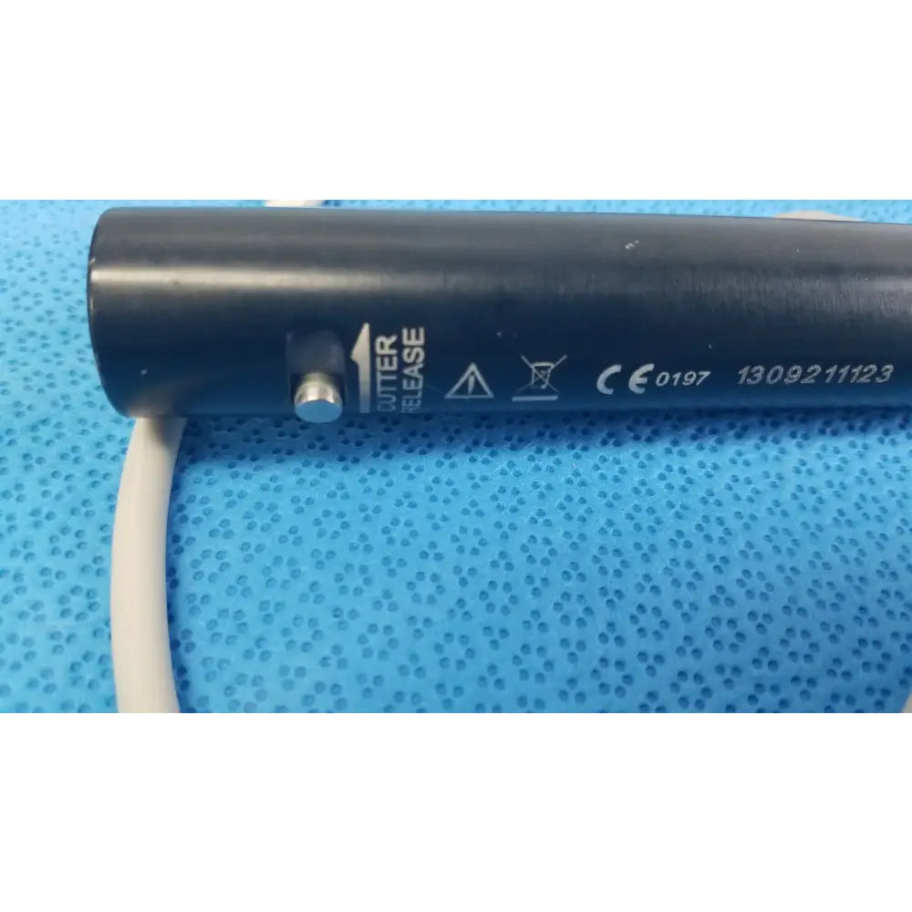 Black cylindrical stryker essx microdebrider handpiece with silver release button and white cable for reuse medical equipment
