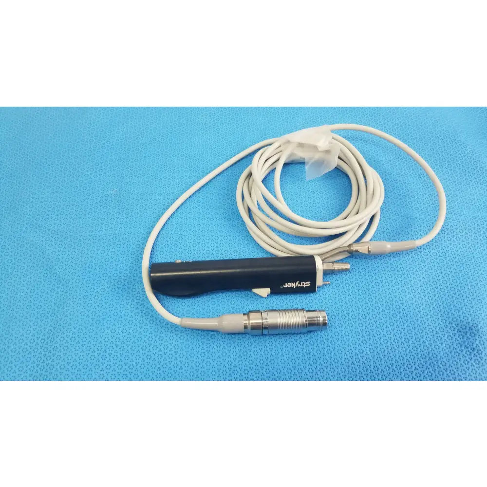 Black cylindrical Stryker ESSx microdebrider handpiece with silver connector and coiled white cable for medical equipment reuse