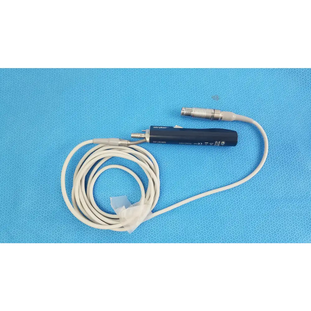 Black stryker essx microdebrider handpiece with coiled white cable and metallic connectors for reuse medical equipment