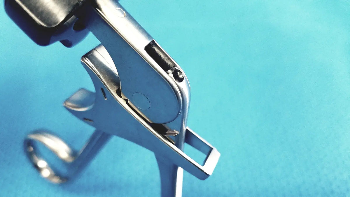 Silver surgical speculum with sleek polished metal finish and black rubberized handles for stryker fenestrrated delicate grasper