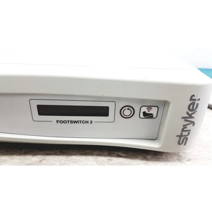 White stryker iswitch wireless universal foot control pedal with digital display and two control icons for surgical use