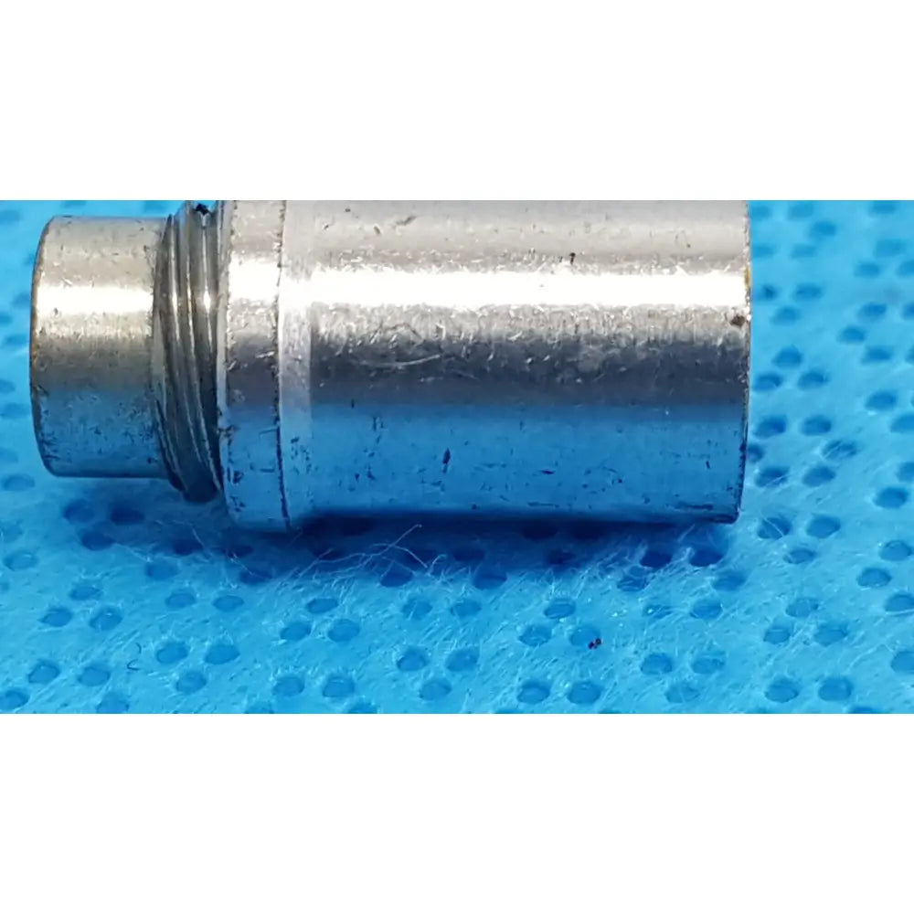 Silver metallic cylindrical stryker light post adapter with threaded end and minor wear for fiber optic cables