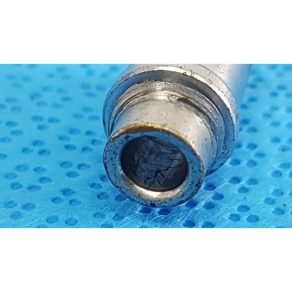 Silver metallic cylindrical stryker light post adapter with threaded interior and wear marks for storz and olympus cables