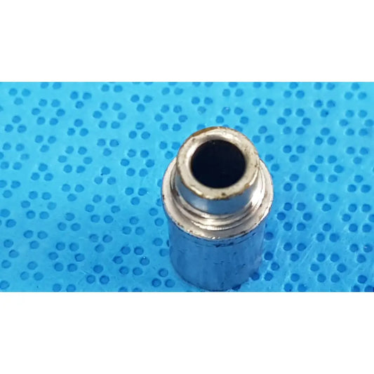 Silver metallic cylindrical stryker light post adapter with threaded interior and worn edges for fiber optic cables
