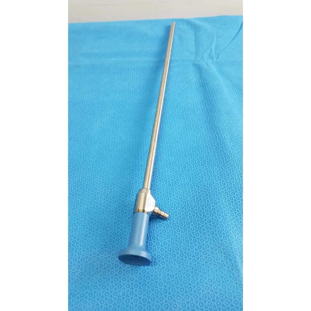 Slender metallic stryker lot autoclavable 10mm 30º endoscope with blue plastic handle and brass fittings with sterilization tray