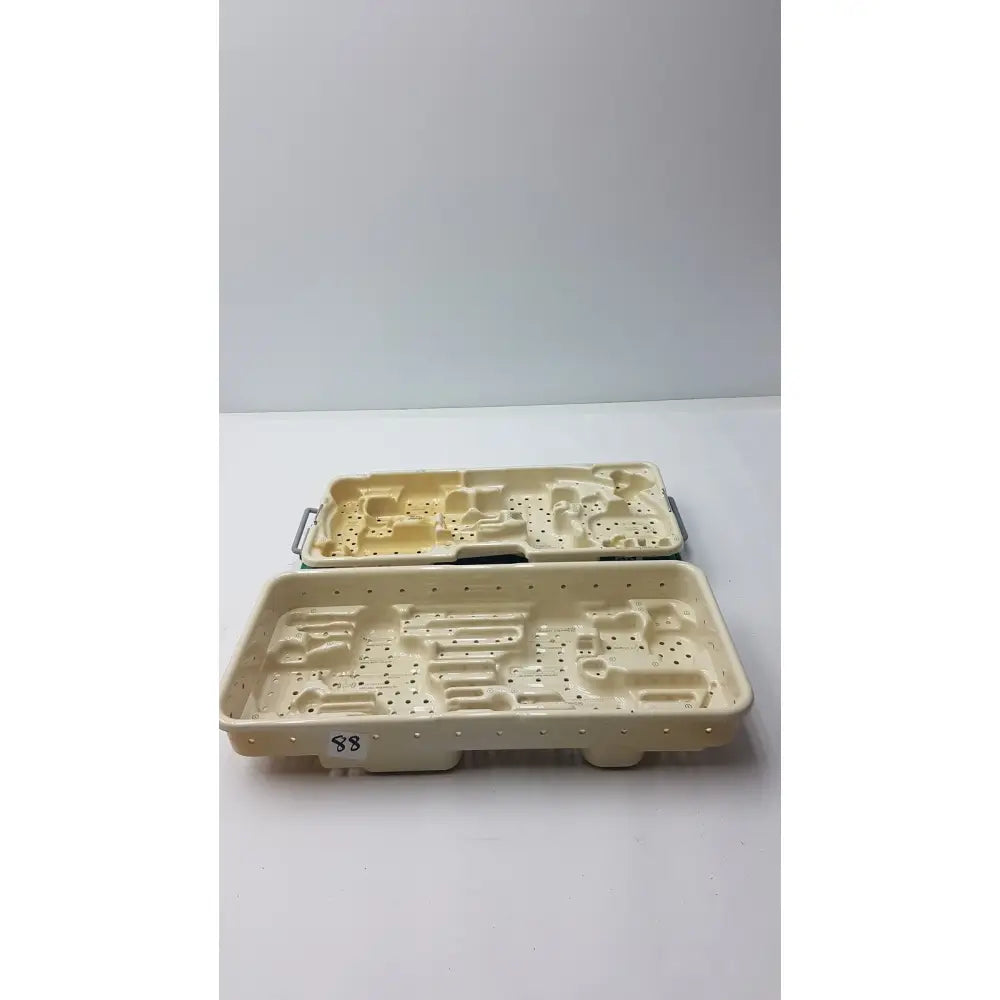 Cream-colored plastic stryker optional instrument tray with molded compartments and perforated sides for instrument ray gamma3 system