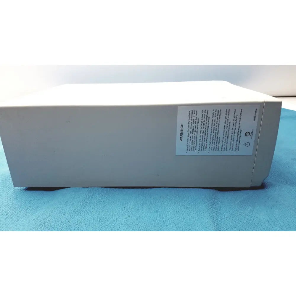 Beige rectangular electronic stryker pneumo high flow insufflator with white warning label on side for medical use