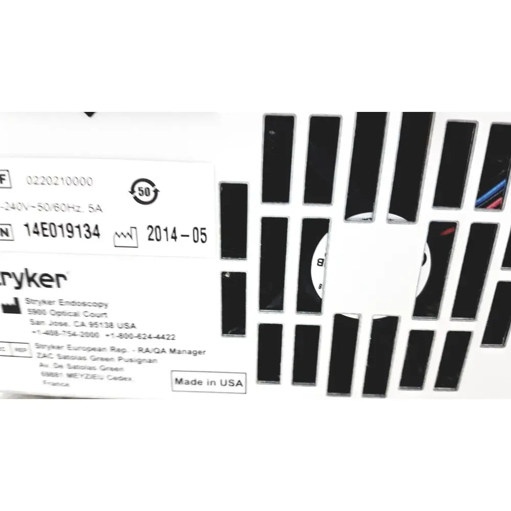 White stryker precision light source label with black text and ventilation slots on the back of surgical illumination unit