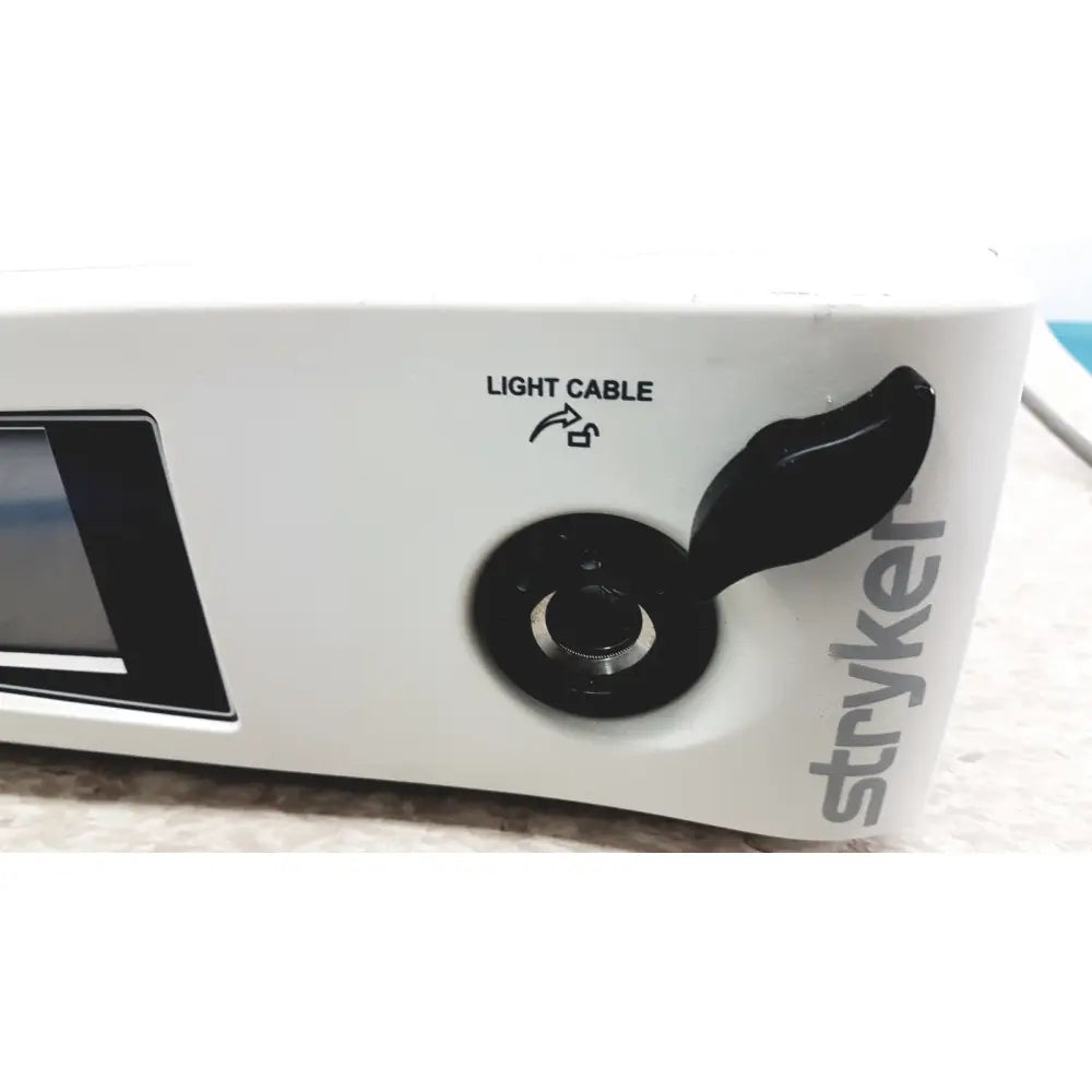 White stryker precision light source with black rotary knob and light cable label surgical illumination unit