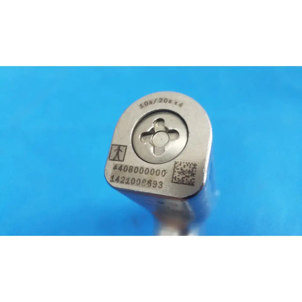 Silver-colored metal die with engraved markings and qr code on the back of stryker sago 2 surgical orthopedic reciprocating saw
