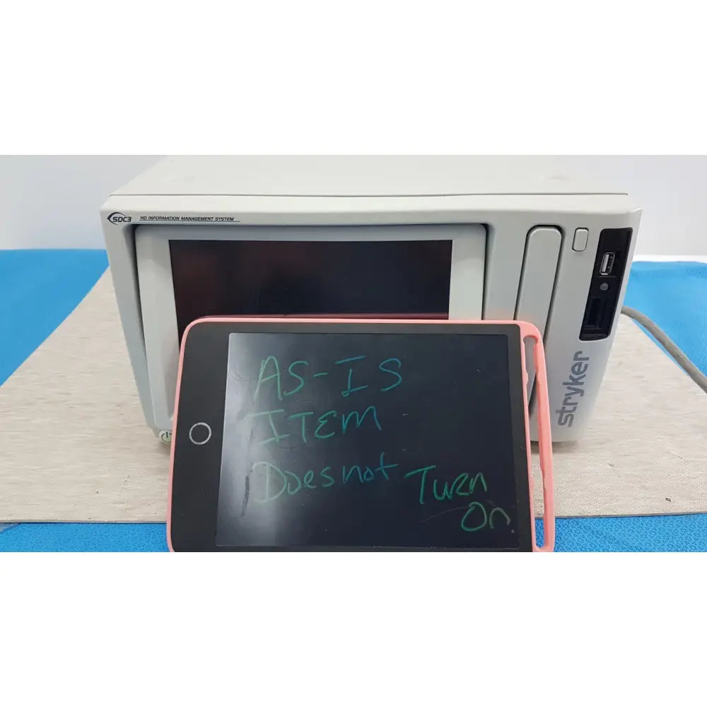 Pink-framed tablet displaying handwritten text in front of white stryker sdc3 hd digital capture unit information management system