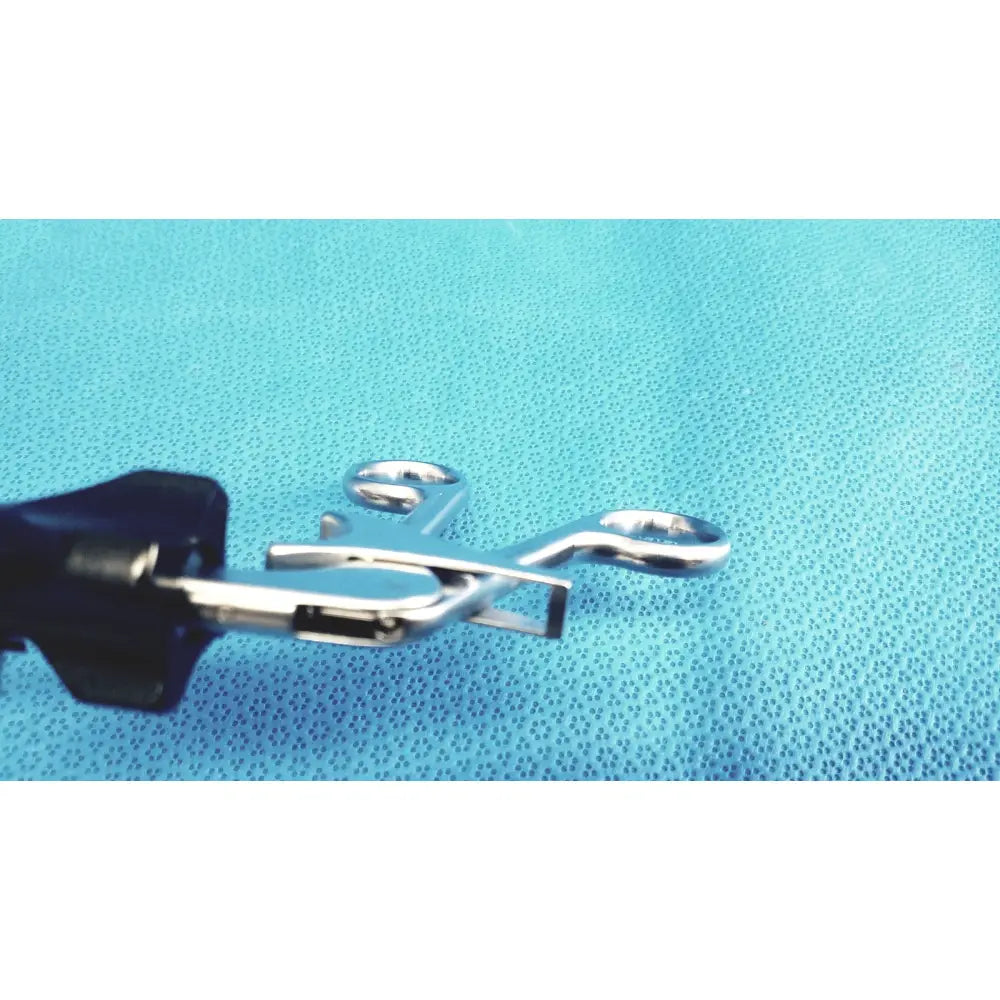 Stryker stainless steel laparoscopiic clamp with silver forceps and black handles on a blue textured surface