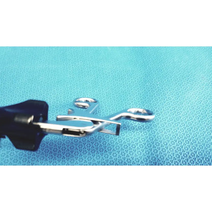 Stryker stainless steel laparoscopiic clamp with silver forceps and black handles on a blue textured surface