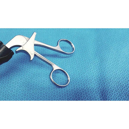 Silver stryker stainless steel laparoscopiic clamp with black rubberized grip resting on blue textured surface