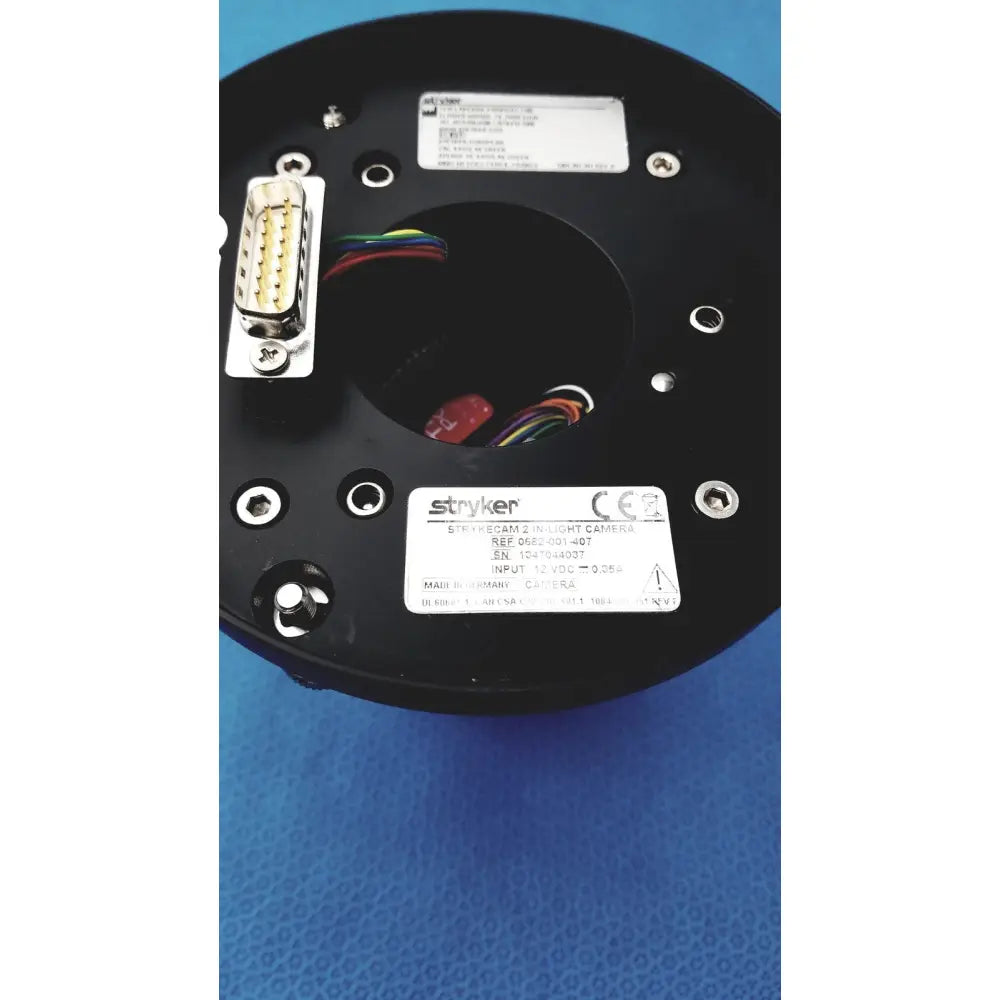Black circular base of Stryker Strykecam 2 in-light camera with metallic connectors and color-coded wires visible from back side