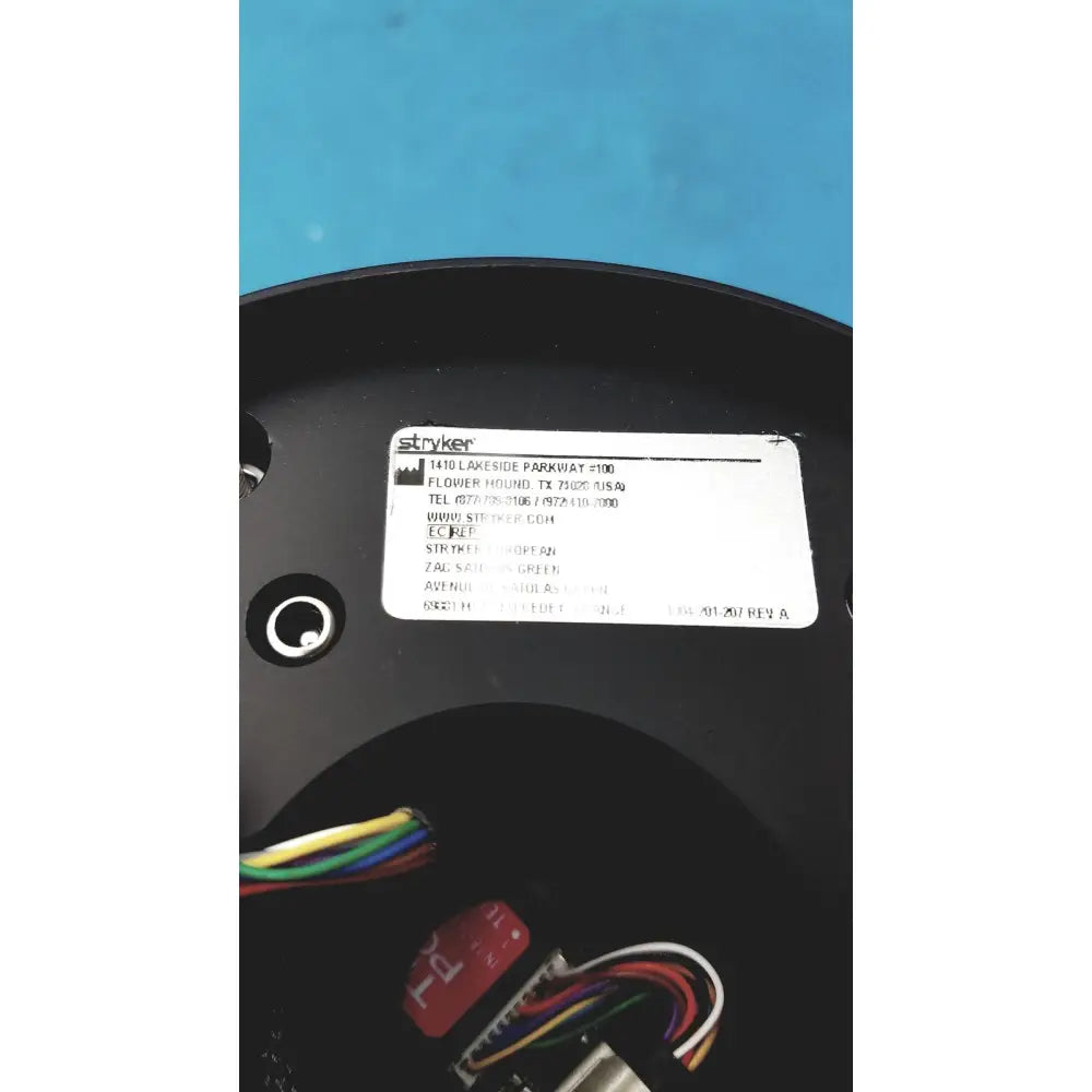Black plastic circular base with white label showing stryker brand and contact info on stryker strykecam 2 in- light camera