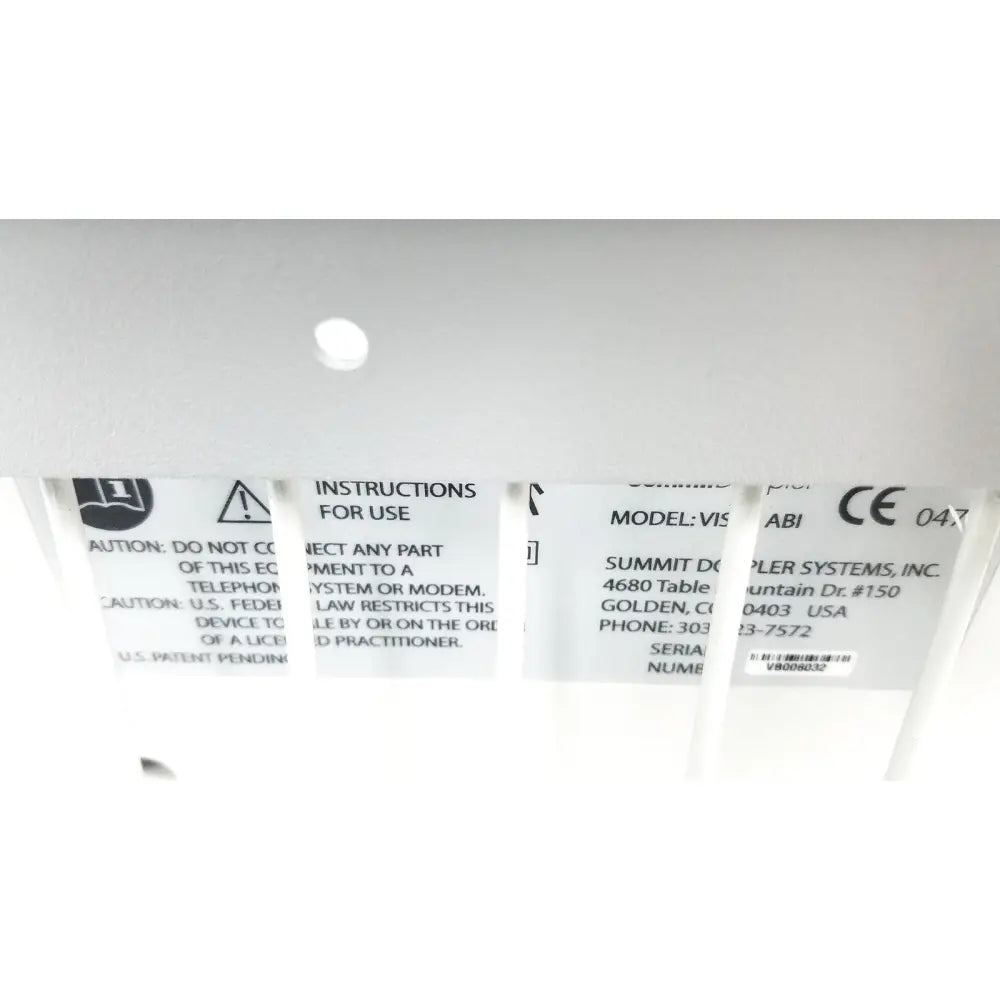 White plastic label with black text showing model and safety info on the back of summiit doppller vista abi reuse medical device