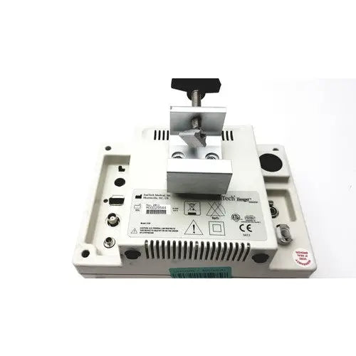 White plastic industrial device with metallic clamp and black knob on suntech medical tango+ patient monitor