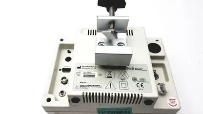 White plastic industrial device with metallic clamp and black knob on suntech medical tango+ patient monitor