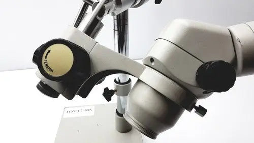 Silver and black dental surgical microscope with adjustable arms and labeled focus knob featuring eyepieces 23mm swh10x for super widefield microscope use