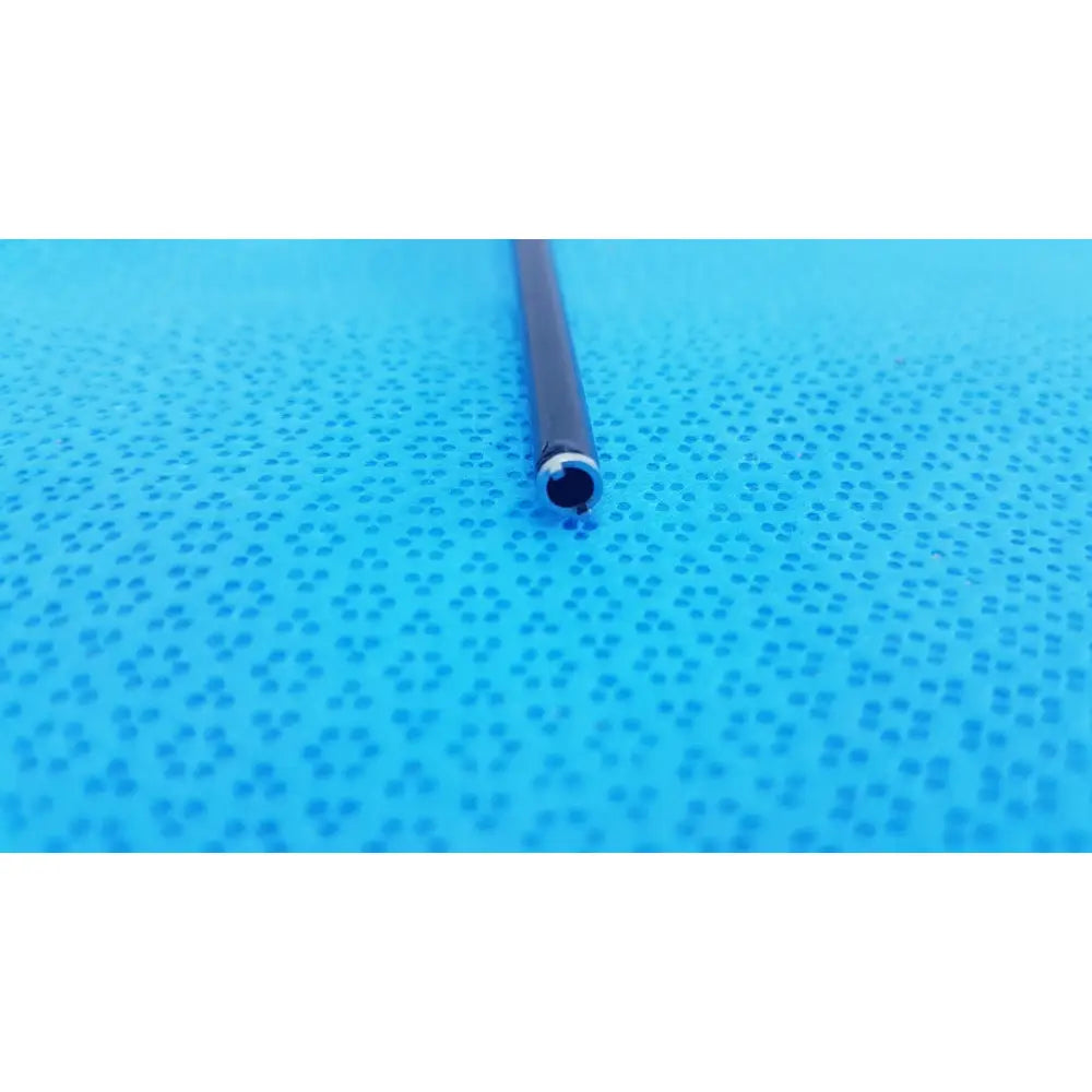 Black surgical cannula sheath with metallic silver luer lock ring resting on blue textured surface