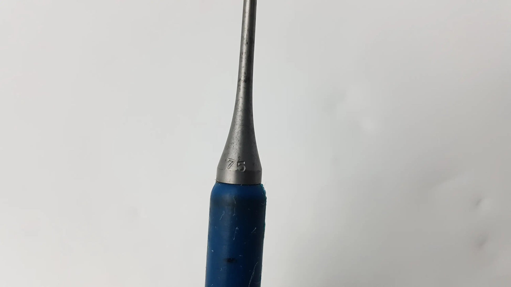 Blue-handled metal dental instrument with tapered silver needle probe tip marked 75 compatible dental instrument tool