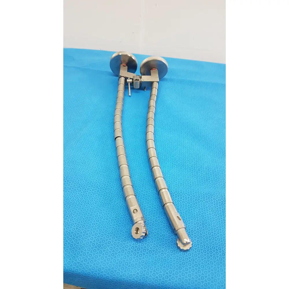 A pair of metallic segmented surgical snake flexarm retractors with circular heads and adjustable ends for or procedures