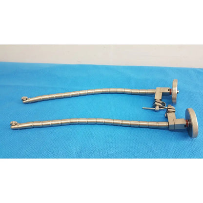 Two metallic silver surgical snake flexarm instruments with segmented joints and circular handpieces for OR use