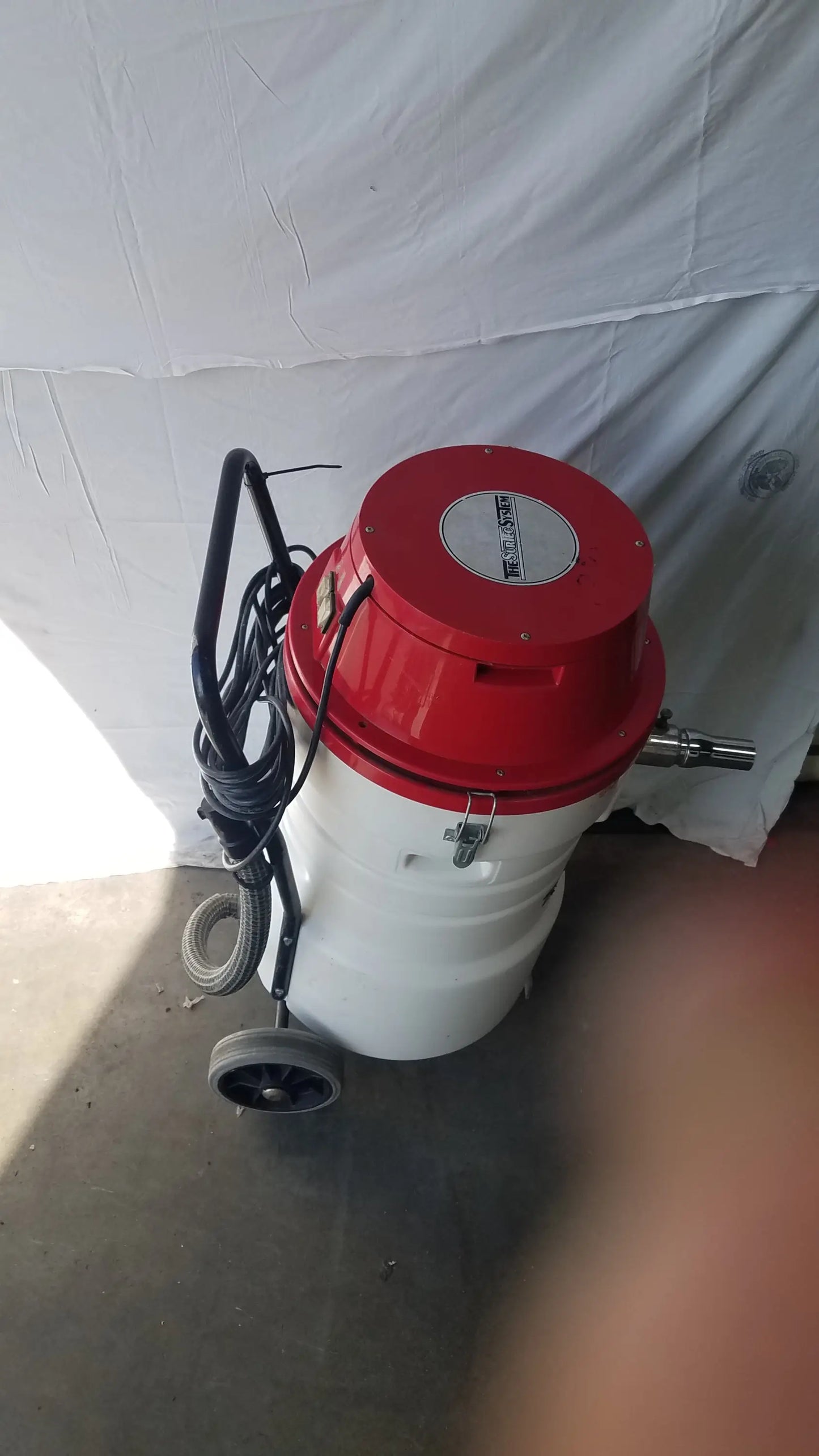 Surtec system c72f1 wet dry vacuum cleaner 115v with red and white cylindrical body, black handle and coiled hose on wheels