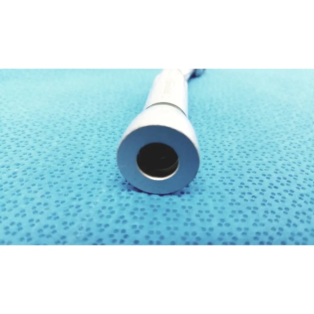 White cylindrical sybronendo axxess spring-head handpiece with smooth tapered end and central opening for dental use