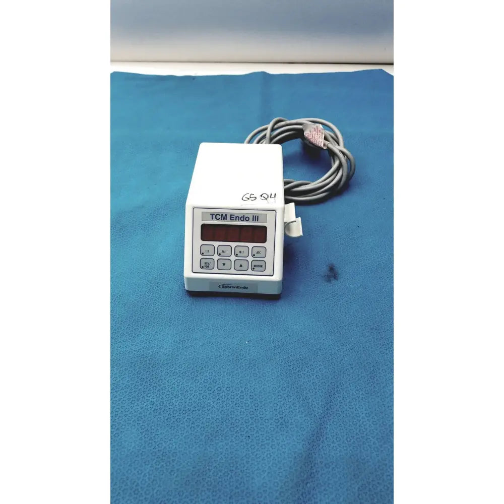 White plastic sybronendo tcm endo iii medical device with red digital display keypad and coiled gray tubing attached