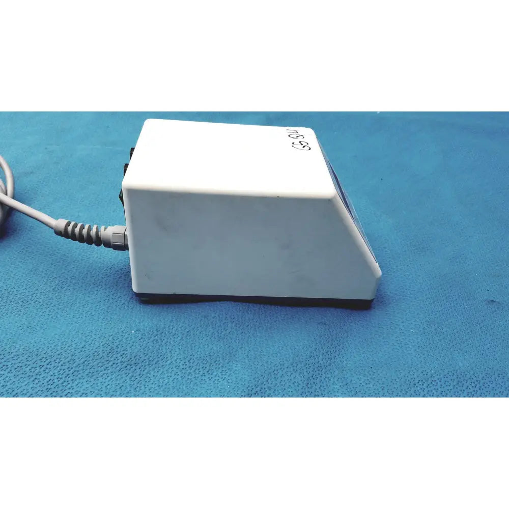 White rectangular foot pedal with coiled gray power cord and black base for sybronendo tcm endo iii device