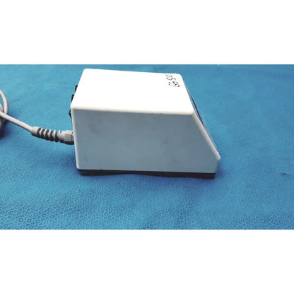 White rectangular foot pedal with coiled gray power cord and black base for sybronendo tcm endo iii device