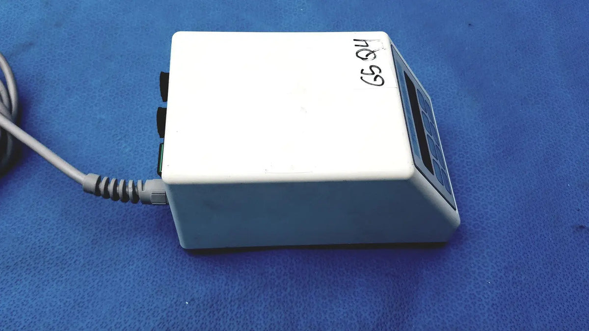 White rectangular electronic sybronendo tcm endo iii device with digital display control buttons and gray coiled power cord attached
