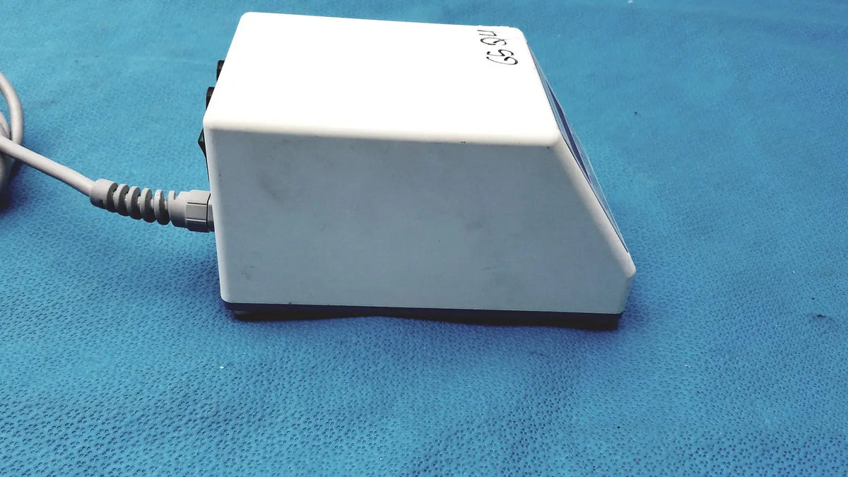 White rectangular foot pedal with coiled gray power cord and black base for sybronendo tcm endo iii device