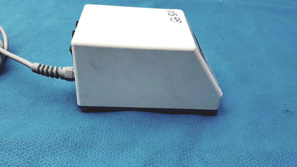 White rectangular foot pedal with coiled gray power cord and black base for sybronendo tcm endo iii device